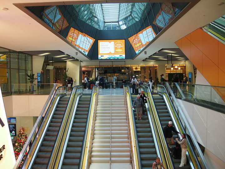 Quad escalators, split by a pair of stairs, beneath an atrium