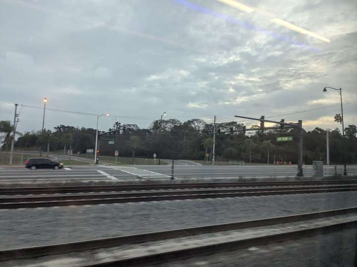 A view out the window of a train at speed, passing an intersection