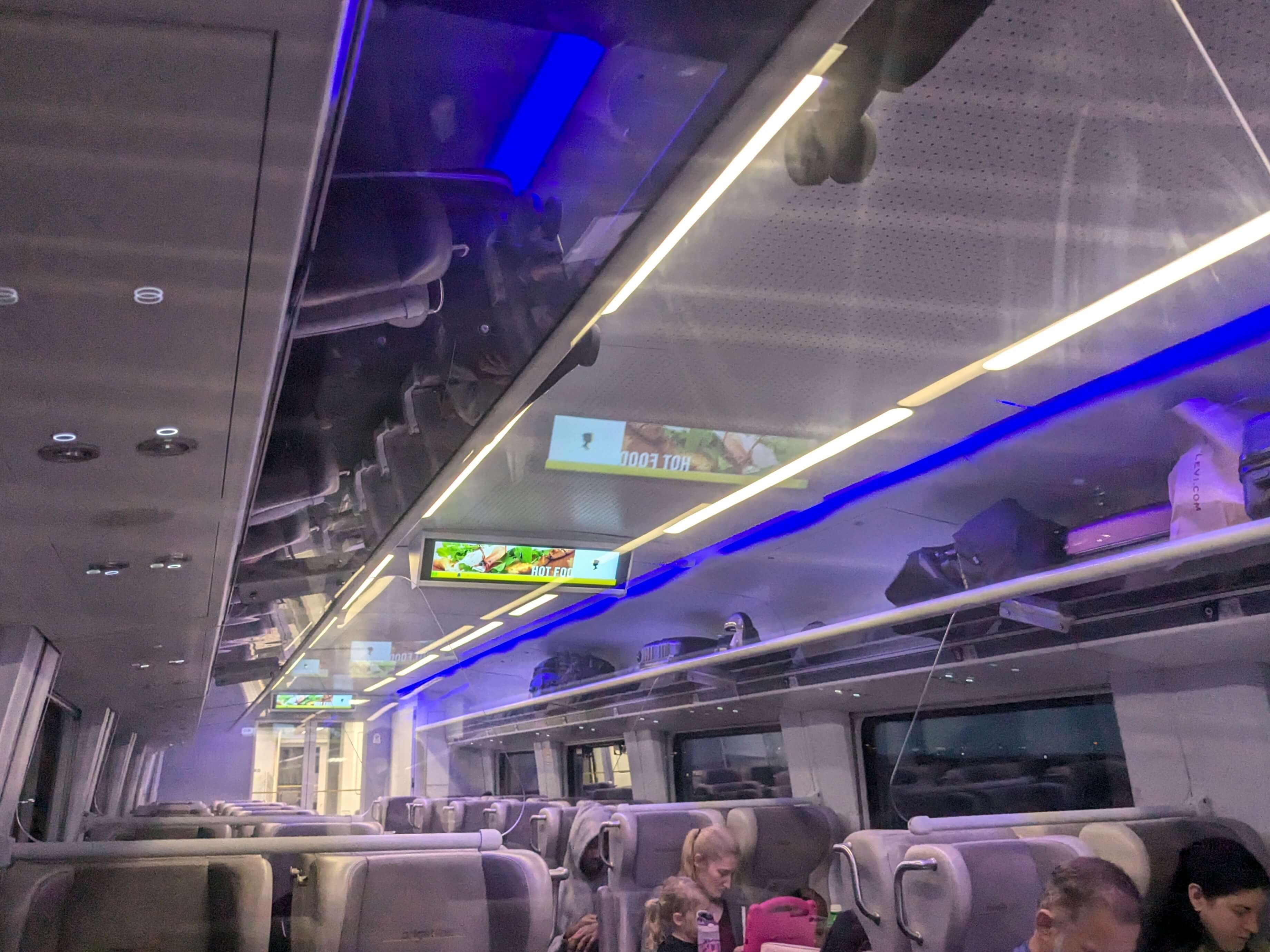 The interior of a modern passenger train car in the dark early morning