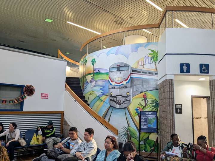 A mural depicting a 90s streamlined locomotive on the wall behind a curved staircase