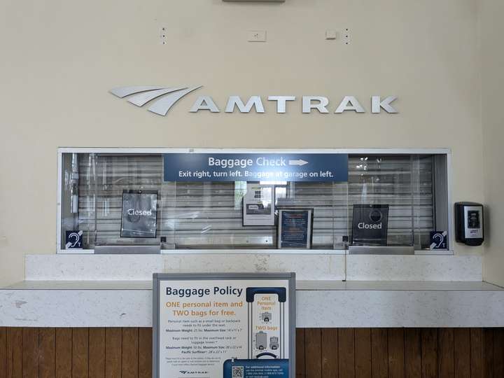 A shuttered ticket counter with a silver Amtrak logo over top